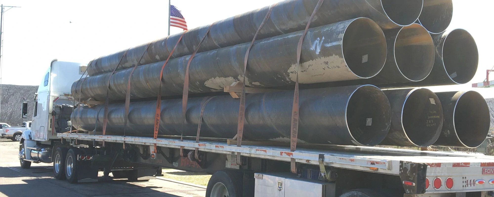 A truck loaded with large metal pipes A truck loaded with large metal pipes
